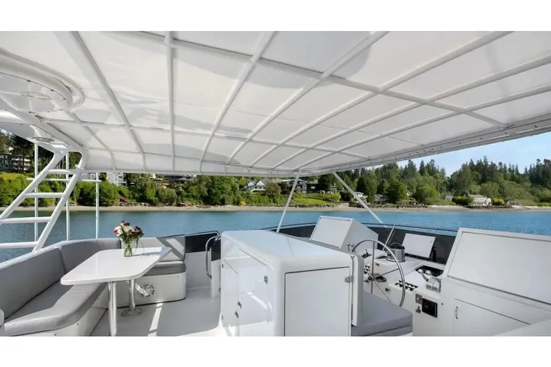 First Home Yacht Photos Pics Luxurious 1988 Cheoy Lee 92 yacht deck with seating, table, and scenic waterfront view.