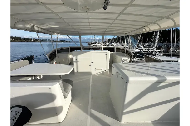 First Home Yacht Photos Pics 1988 Cheoy Lee 92 yacht deck with seating and table, docked at marina.