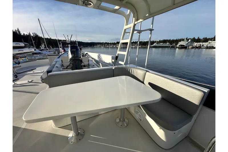 First Home Yacht Photos Pics Outdoor seating area on 1988 Cheoy Lee 92 yacht, overlooking marina with calm waters.