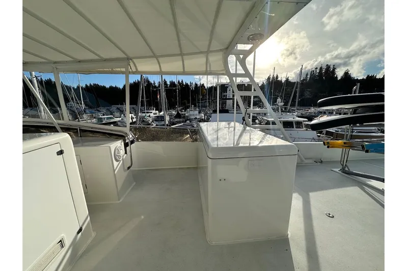 First Home Yacht Photos Pics 1988 Cheoy Lee 92 yacht deck with marina view, featuring white structures and seating.