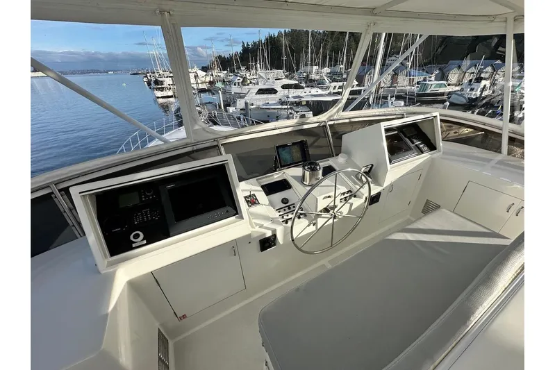 First Home Yacht Photos Pics Helm of 1988 Cheoy Lee 92 yacht with navigation equipment, overlooking marina.