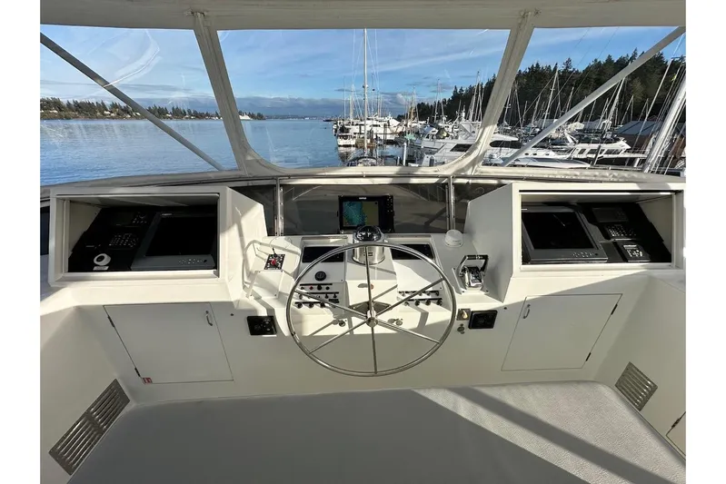 First Home Yacht Photos Pics Helm of 1988 Cheoy Lee 92 yacht with navigation equipment, overlooking marina.