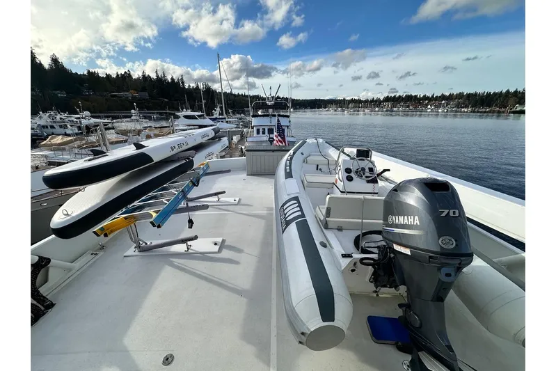 First Home Yacht Photos Pics Deck of 1988 Cheoy Lee 92 yacht with Yamaha motor and paddleboards, docked in marina.