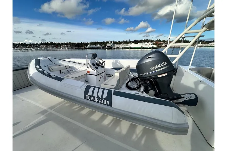 First Home Yacht Photos Pics Novurania inflatable boat with Yamaha motor on Cheoy Lee 92 yacht, 1988 model, docked by the water.