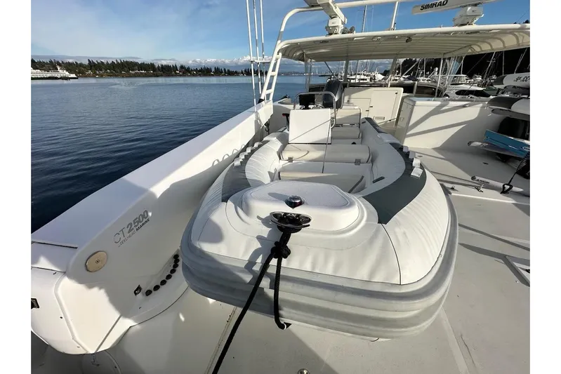 First Home Yacht Photos Pics 1988 Cheoy Lee 92 yacht deck with inflatable boat, docked in marina.