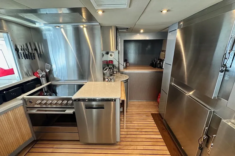 First Home Yacht Photos Pics Modern kitchen in 1988 Cheoy Lee 92 yacht with stainless steel appliances and wooden flooring.