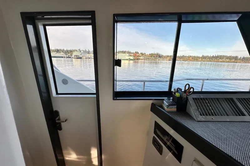 First Home Yacht Photos Pics Interior view of 1988 Cheoy Lee 92 yacht with scenic water and shoreline through windows.