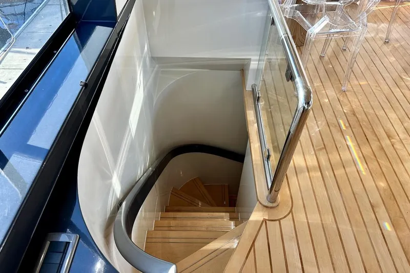 First Home Yacht Photos Pics Staircase on 1988 Cheoy Lee 92 yacht with wooden flooring and glass railing.