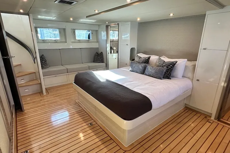 First Home Yacht Photos Pics Luxurious 1988 Cheoy Lee 92 yacht bedroom with modern decor and wooden flooring.
