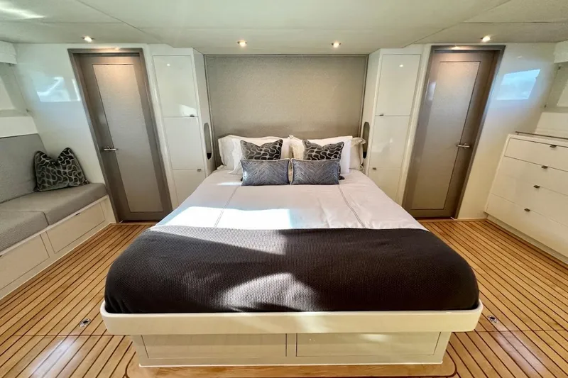 First Home Yacht Photos Pics Luxurious bedroom interior of 1988 Cheoy Lee 92 yacht with modern decor and wood flooring.