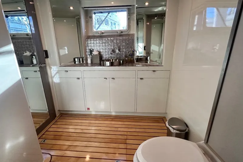 First Home Yacht Photos Pics Luxurious bathroom on 1988 Cheoy Lee 92 yacht with modern fixtures and wooden flooring.