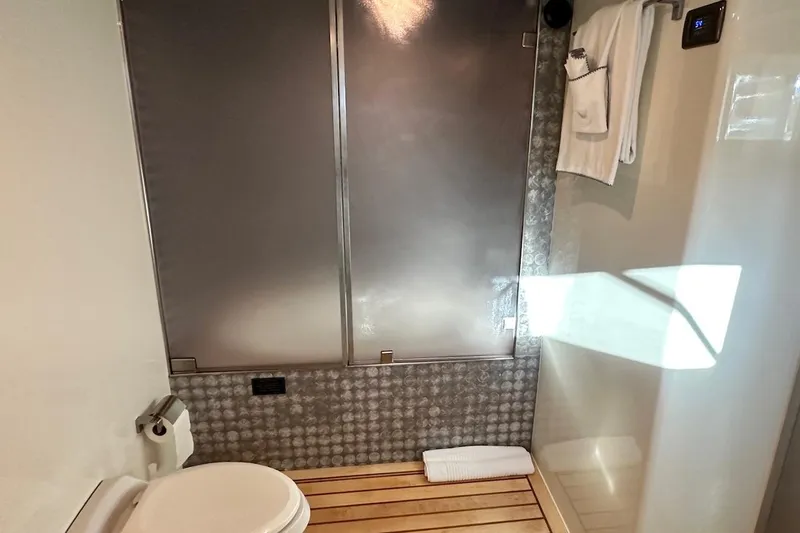 First Home Yacht Photos Pics Bathroom interior of 1988 Cheoy Lee 92 yacht with modern fixtures and wooden flooring.