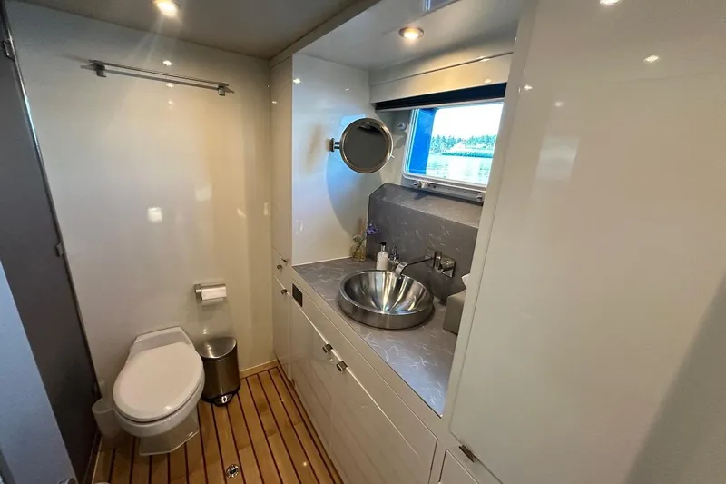 First Home Yacht Photos Pics Luxurious bathroom on 1988 Cheoy Lee 92 yacht with modern fixtures and wooden flooring.