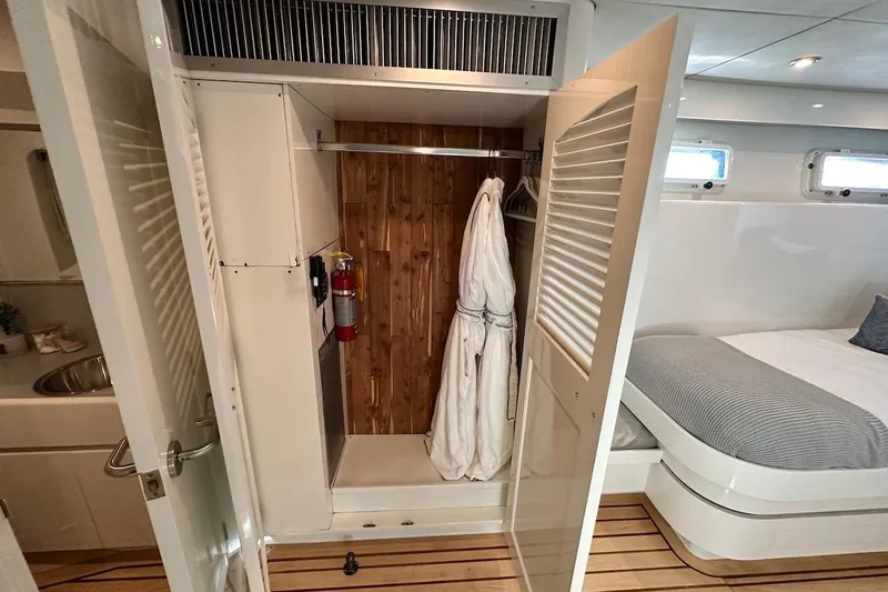 First Home Yacht Photos Pics Luxurious 1988 Cheoy Lee 92 yacht cabin with closet, robe, and bed.