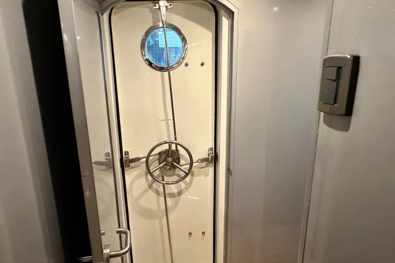 First Home Yacht Photos Pics Interior view of a 1988 Cheoy Lee 92 yacht with a nautical door and porthole.