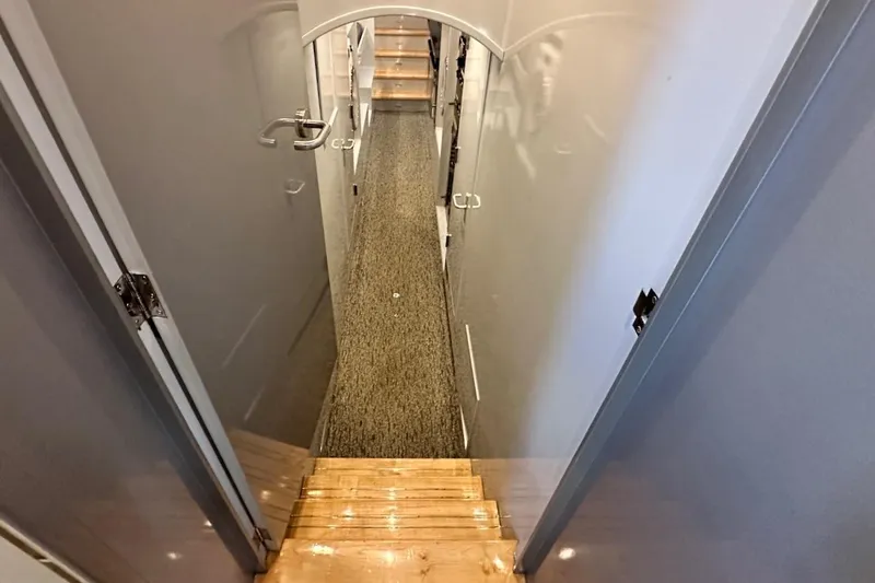 First Home Yacht Photos Pics Interior view of 1988 Cheoy Lee 92 yacht, featuring a narrow hallway and wooden steps.