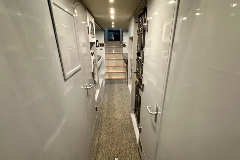 First Home Yacht Photos Pics Narrow hallway inside 1988 Cheoy Lee 92 yacht, featuring sleek white walls and modern lighting.