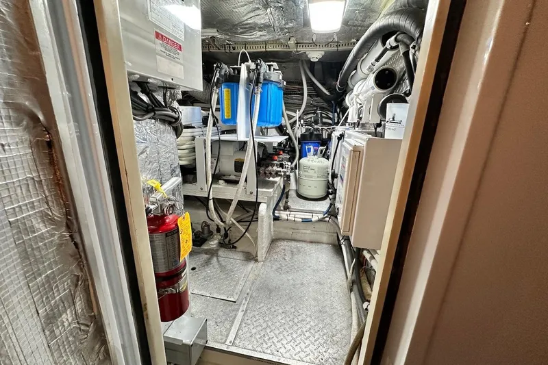 First Home Yacht Photos Pics Engine room of 1988 Cheoy Lee 92 yacht, featuring equipment and fire extinguisher.