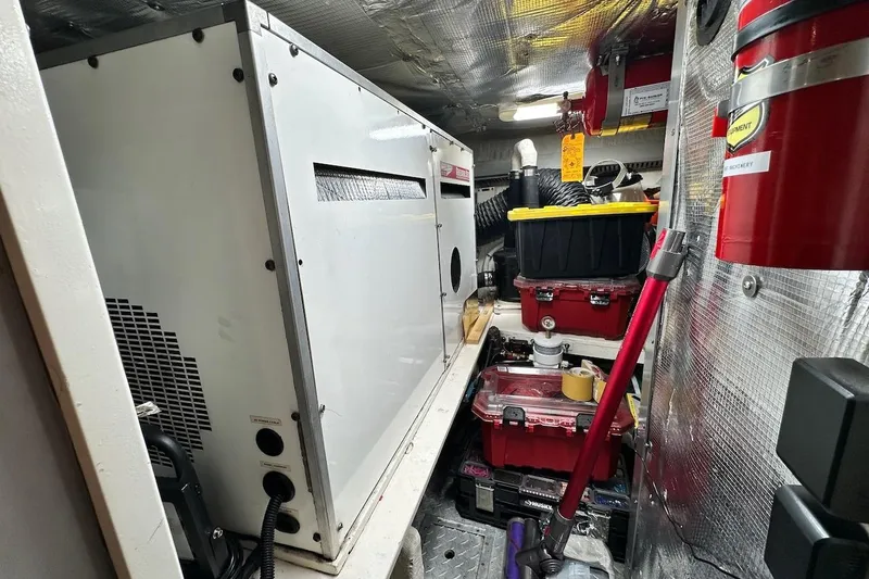 First Home Yacht Photos Pics Engine room of a 1988 Cheoy Lee 92 yacht with equipment and storage boxes.