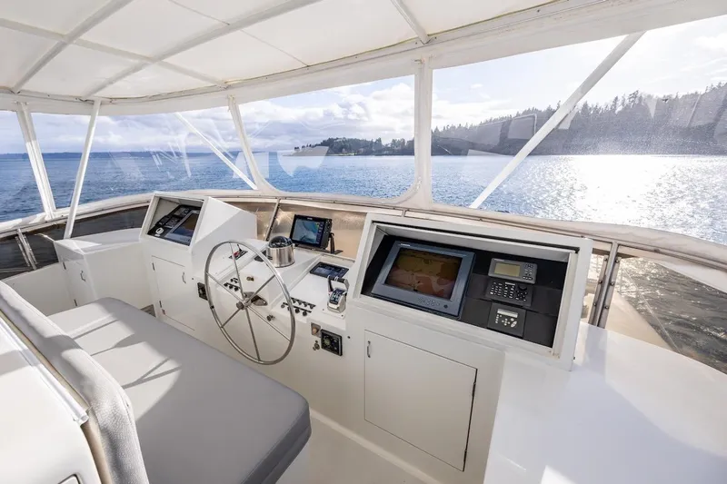 First Home Yacht Photos Pics Helm of 1988 Cheoy Lee 92 yacht with navigation equipment, overlooking serene waters.