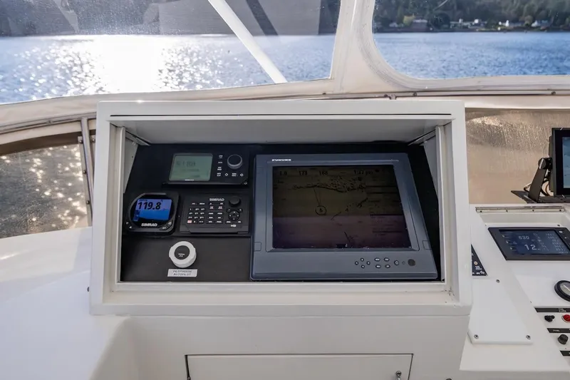 First Home Yacht Photos Pics Control panel of 1988 Cheoy Lee 92 yacht with navigation equipment and scenic water view.