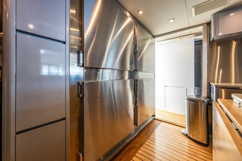 First Home Yacht Photos Pics Stainless steel kitchen interior on 1988 Cheoy Lee 92 yacht with wooden flooring.