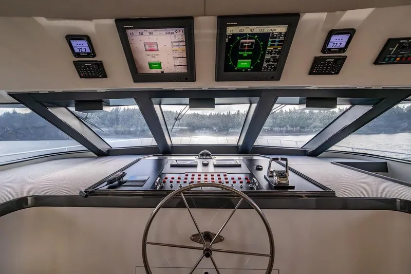 First Home Yacht Photos Pics Helm of 1988 Cheoy Lee 92 yacht with navigation screens and steering wheel.