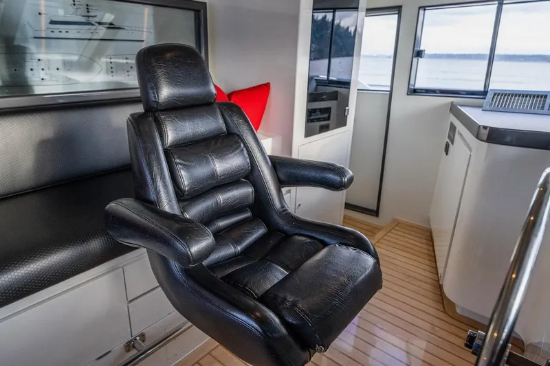 First Home Yacht Photos Pics Luxurious black leather captain's chair in 1988 Cheoy Lee 92 yacht interior.