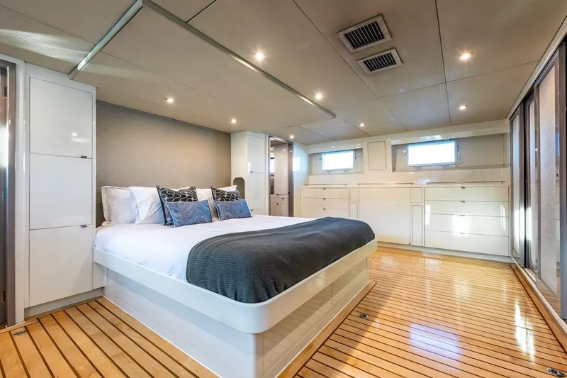 First Home Yacht Photos Pics Luxurious bedroom interior of 1988 Cheoy Lee 92 yacht with modern design and wooden flooring.