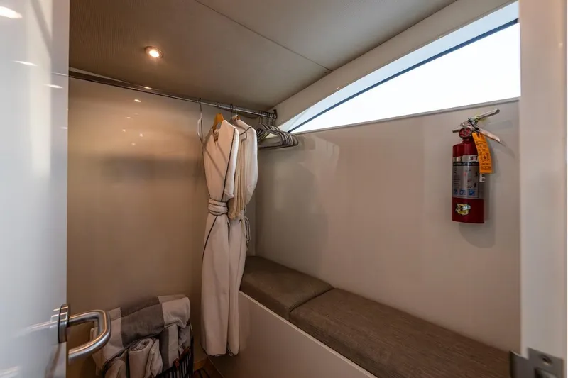 First Home Yacht Photos Pics Luxurious Cheoy Lee 92 yacht closet with robes, seating, and fire extinguisher, 1988 model.
