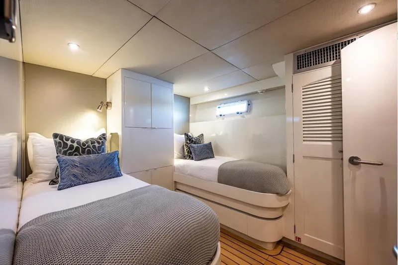 First Home Yacht Photos Pics Luxurious twin cabin interior on 1988 Cheoy Lee 92 yacht, featuring elegant bedding and modern lighting.