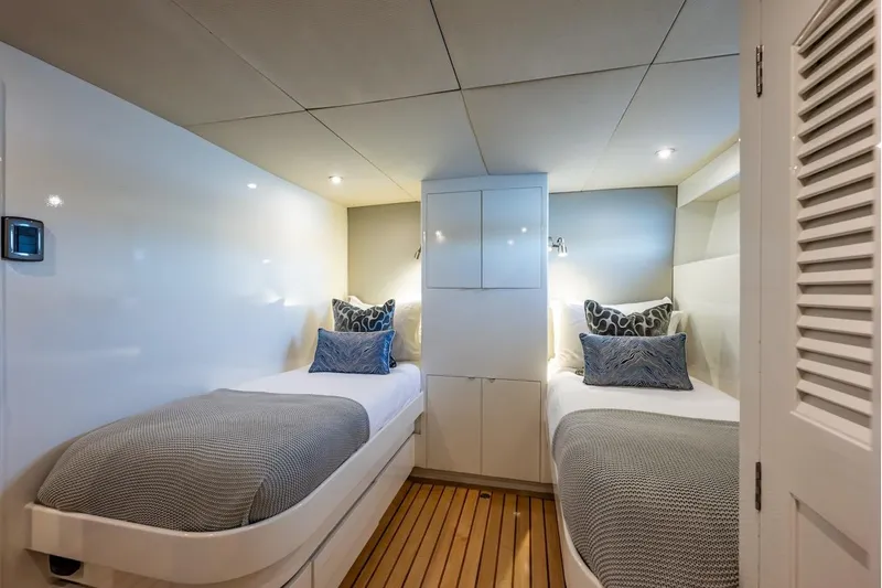 First Home Yacht Photos Pics Twin cabin interior of 1988 Cheoy Lee 92 yacht with modern decor and cozy lighting.