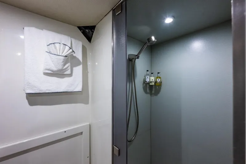 First Home Yacht Photos Pics Luxurious shower area in 1988 Cheoy Lee 92 yacht with modern fixtures and elegant towels.