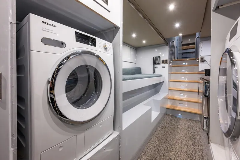 First Home Yacht Photos Pics Laundry area and stairs inside a 1988 Cheoy Lee 92 yacht, featuring modern appliances.