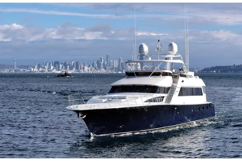 First Home Yacht Photos Pics 1988 Cheoy Lee 92 yacht cruising near a city skyline on a clear day.