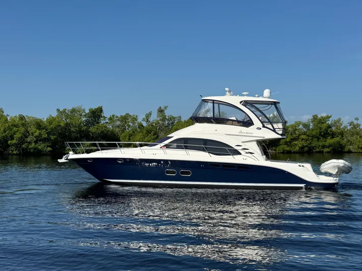Last Mango Yacht Photos Pics 2007 Sea Ray 52 Sedan Bridge yacht on calm water, clear sky background.