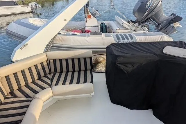 Impulse Yacht Photos Pics Luxury Navigator 57 yacht deck with striped seating and inflatable boat, 2004 model.