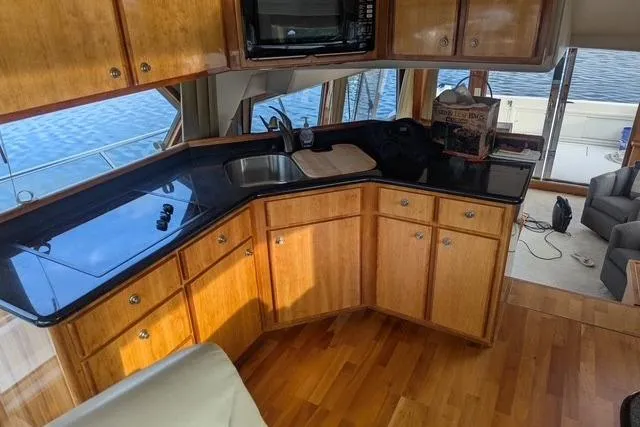 Impulse Yacht Photos Pics Luxurious 2004 Navigator 57 yacht interior with wooden cabinetry and sleek black countertops.