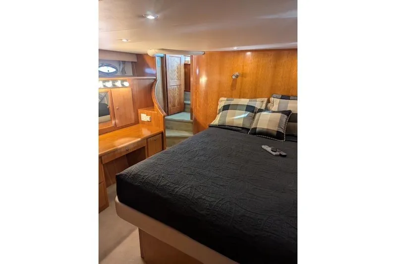 Impulse Yacht Photos Pics Luxurious 2004 Navigator 57 yacht bedroom with wood paneling and cozy bedding.