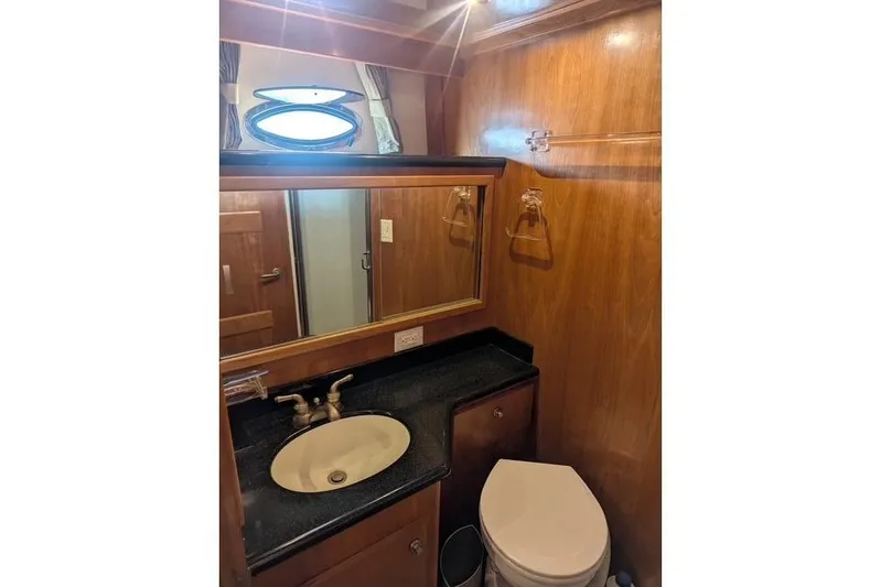 Impulse Yacht Photos Pics 2004 Navigator 57 yacht bathroom with wood paneling, sink, and toilet.
