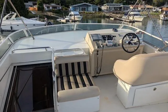 Impulse Yacht Photos Pics 2004 Navigator 57 yacht helm with seating, docked in a serene marina setting.