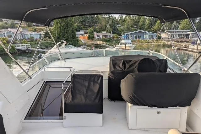 Impulse Yacht Photos Pics 2004 Navigator 57 yacht deck with covered seating, overlooking a serene waterfront community.