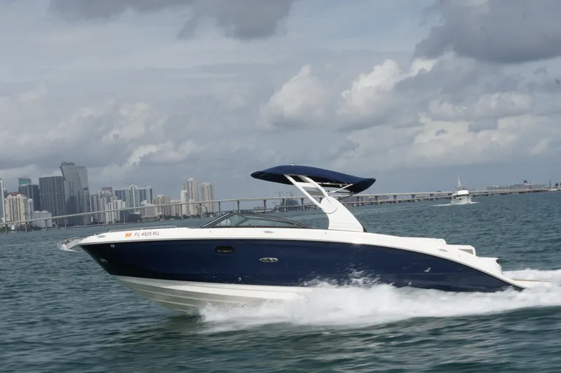  Yacht Photos Pics 2018 Sea Ray SDX 290 cruising on water with city skyline in background.