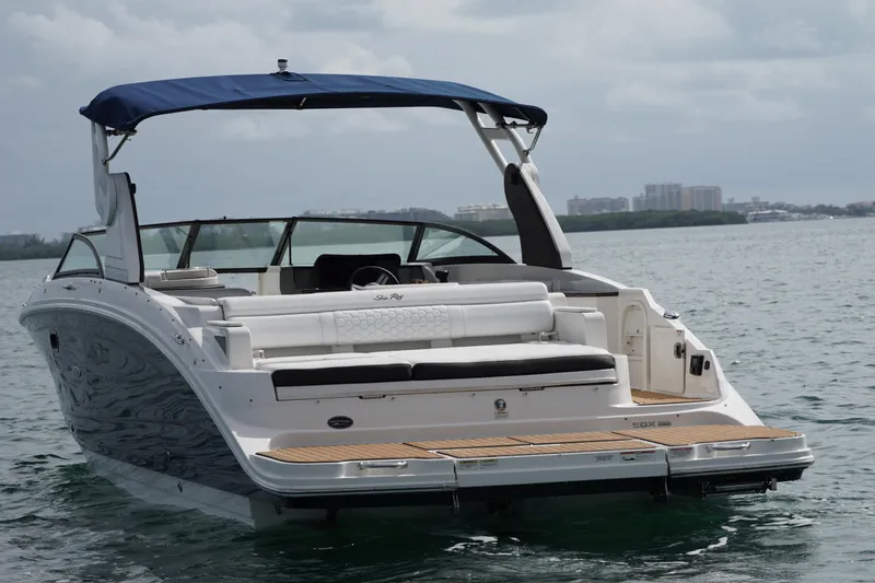  Yacht Photos Pics 2018 Sea Ray SDX 290 boat with blue canopy on calm water.