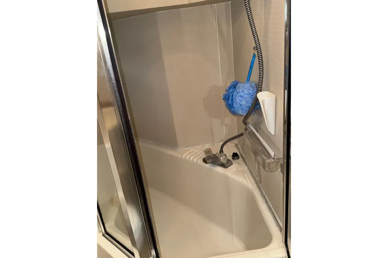 Alexandra Yacht Photos Pics Shower area in 1998 Bayliner 4788 Pilot House Motoryacht with blue loofah and chrome fixtures.