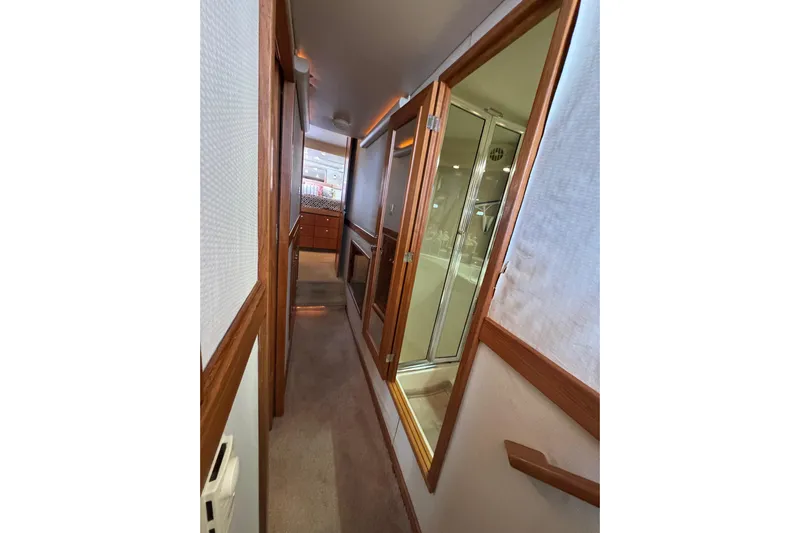 Alexandra Yacht Photos Pics 1998 Bayliner 4788 Pilot House Motoryacht interior hallway with wooden accents and glass shower.