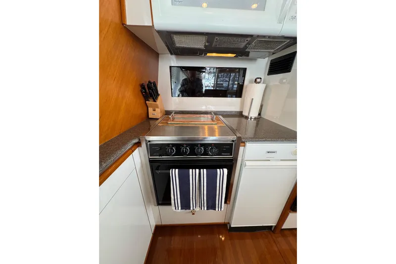 Alexandra Yacht Photos Pics Compact kitchen in 1998 Bayliner 4788 Pilot House Motoryacht with stove and modern appliances.
