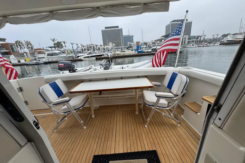 Alexandra Yacht Photos Pics 1998 Bayliner 4788 Pilot House Motoryacht with deck seating, table, and American flags in marina.