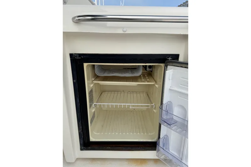Alexandra Yacht Photos Pics Open fridge on 1998 Bayliner 4788 Pilot House Motoryacht, showing empty shelves.