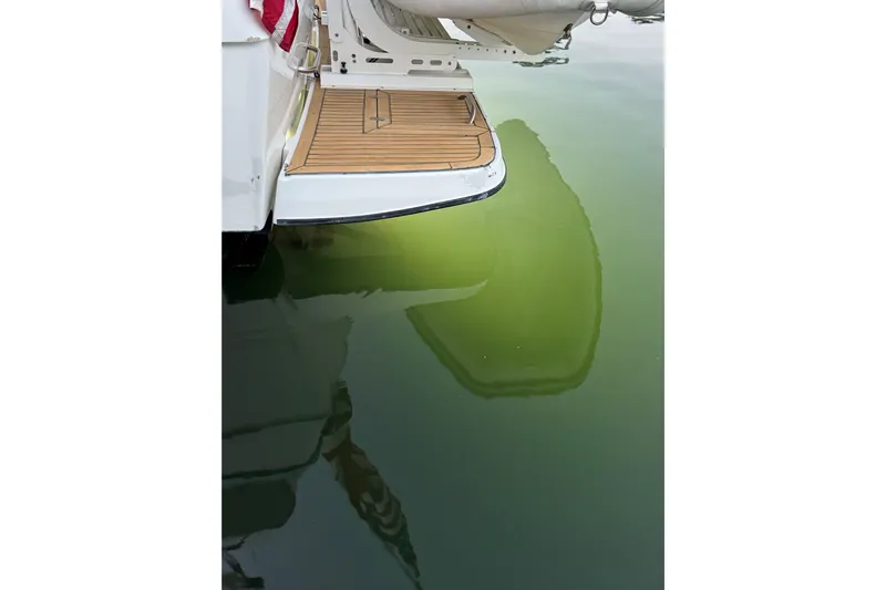 Alexandra Yacht Photos Pics 1998 Bayliner 4788 Pilot House Motoryacht stern with swim platform reflected in calm water.